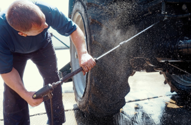 トラクターを清掃している男性