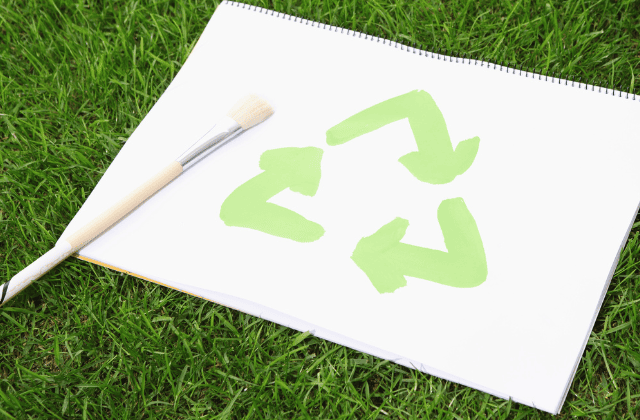 紙に描かれたリサイクルマークと筆